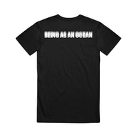image of the back of a black tee shirt on a white background. the tee has a white print across the top shoulders in blurred text that says being as an ocean.