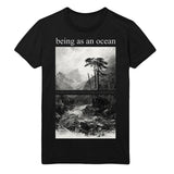 image of a black tee shirt on a white background. tee has a full body print in white. at the top says being as an ocean with a black and white image of a flowing river with mountains in the background and trees on the right.