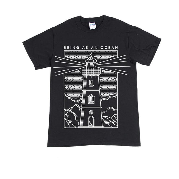 image of a black tee shirt on a white background. tee has a full body print in white that says being as an ocean at the top and an outlined image of a lighthouse with clouds and mountains below