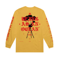 image of the back of a gold long sleeve tee shirt on a white background. the long sleeve  has a full back print of black roses and the words being as an ocean over the roses in red