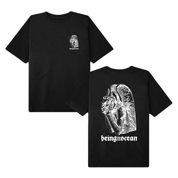 image of the front and back of a black tee shirt on a white background. the front of the tee is on the right and has a small chest print on the right of a white outlined gargoyle with the hands on the cheeks. being as an ocean is written across the bottom. the back of the tee is on the right and has the same image covering the body of the back of the tee shirt