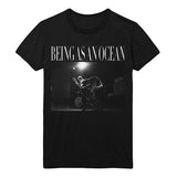 image of a black tee shirt on a white background. tee has full chest print in white that says being as an ocean at the top, with a photograph of two guys in the band playing guitar