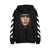 image of the front of a black pullover hoodie on a white background. the hoodie  has a full print above the pouch pocket of a photograph of a woman's face with red hair and blue eyes. there are white lines on each sleeve, and the word OK on the pouch