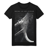 image of a black tee shirt on a white background. tee has a full body print that has at the top in white being as an ocean with a black and white photo of a deer skull with antlers below.