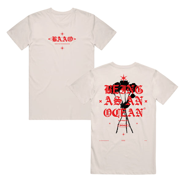 image of the front and back of a natural colored tee shirt on a white background. front of the tee is on the left and has a small center chest print in red of the letters B A A O.  the back of the tee is on the right and has a full back print of black roses and the words being as an ocean over the roses in red