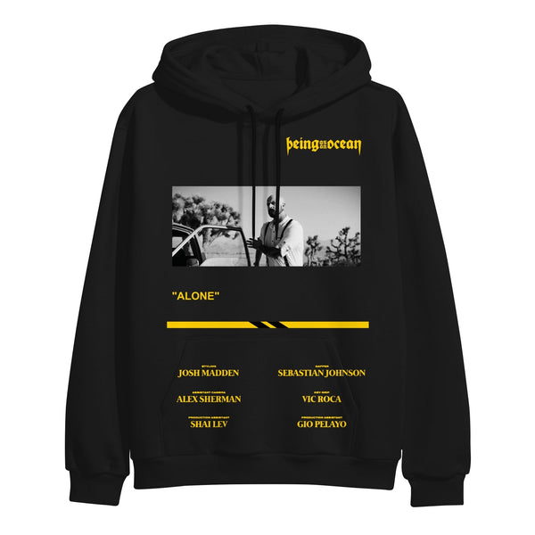 image of a black pullover hoodie on a white background. hoodie has full body print. in yellow at the top right says being as an ocean. below is a black and white image of a bald man opening a car door. below that says alone on the middle left and the band members names in yellow across the pouch pocket